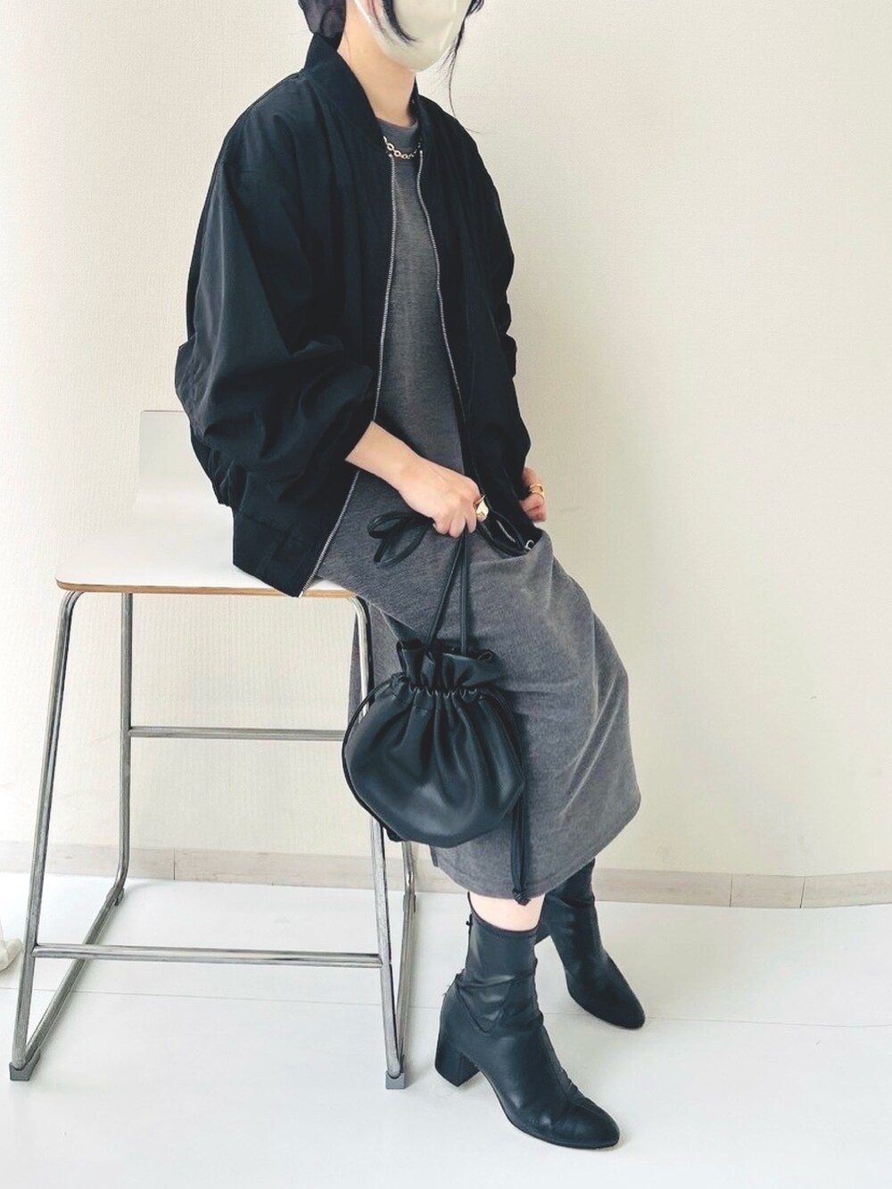 グレー系のワンピース、ブラック系のミリタリージャケットを着用したレディースの春コーディネートの2枚目の写真