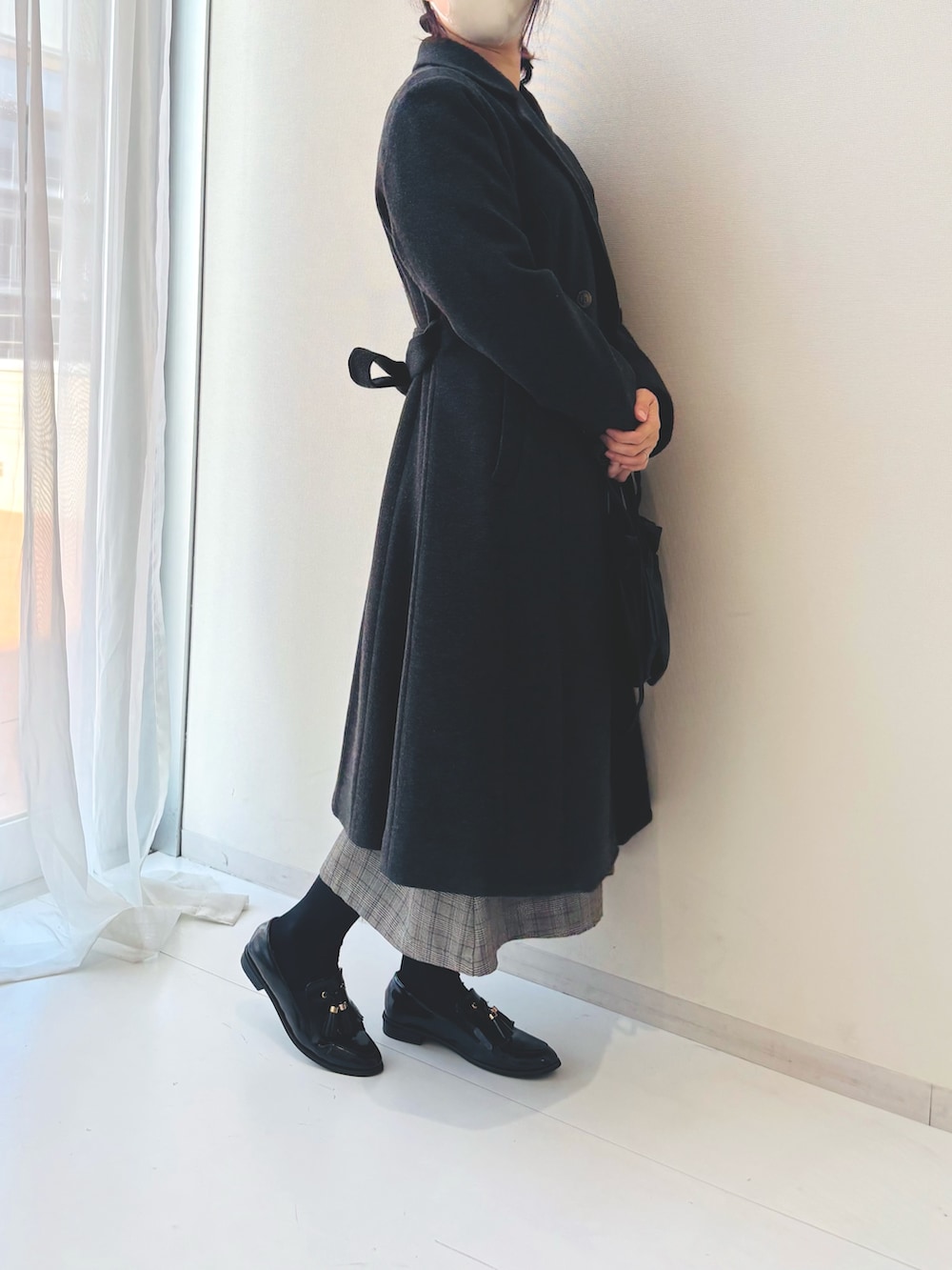 ブラック系のワンピース、ブラック系のパンプスを着用したレディースの冬コーディネートの4枚目の写真