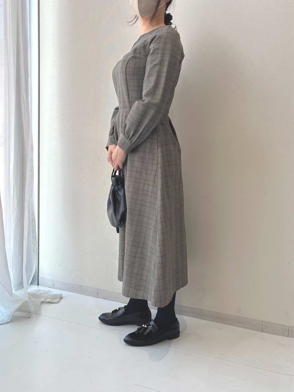 ブラック系のワンピース、ブラック系のパンプスを着用したレディースの冬コーディネートの2枚目の写真