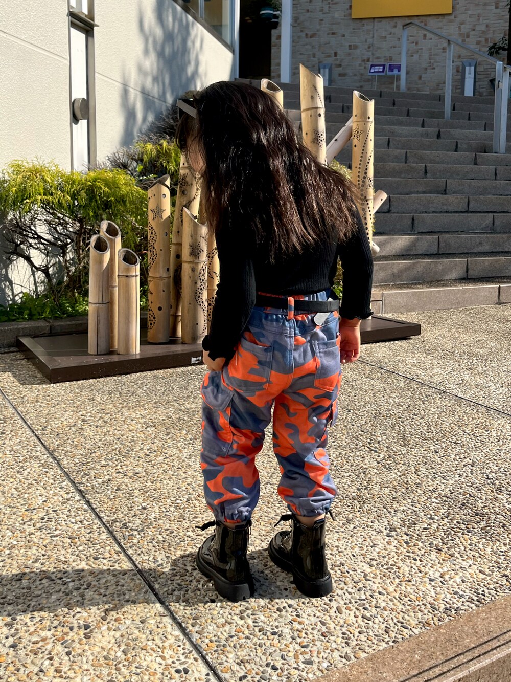 ブラック系のニット/セーター、オレンジ系のカーゴパンツを着用したキッズの冬コーディネートの3枚目の写真