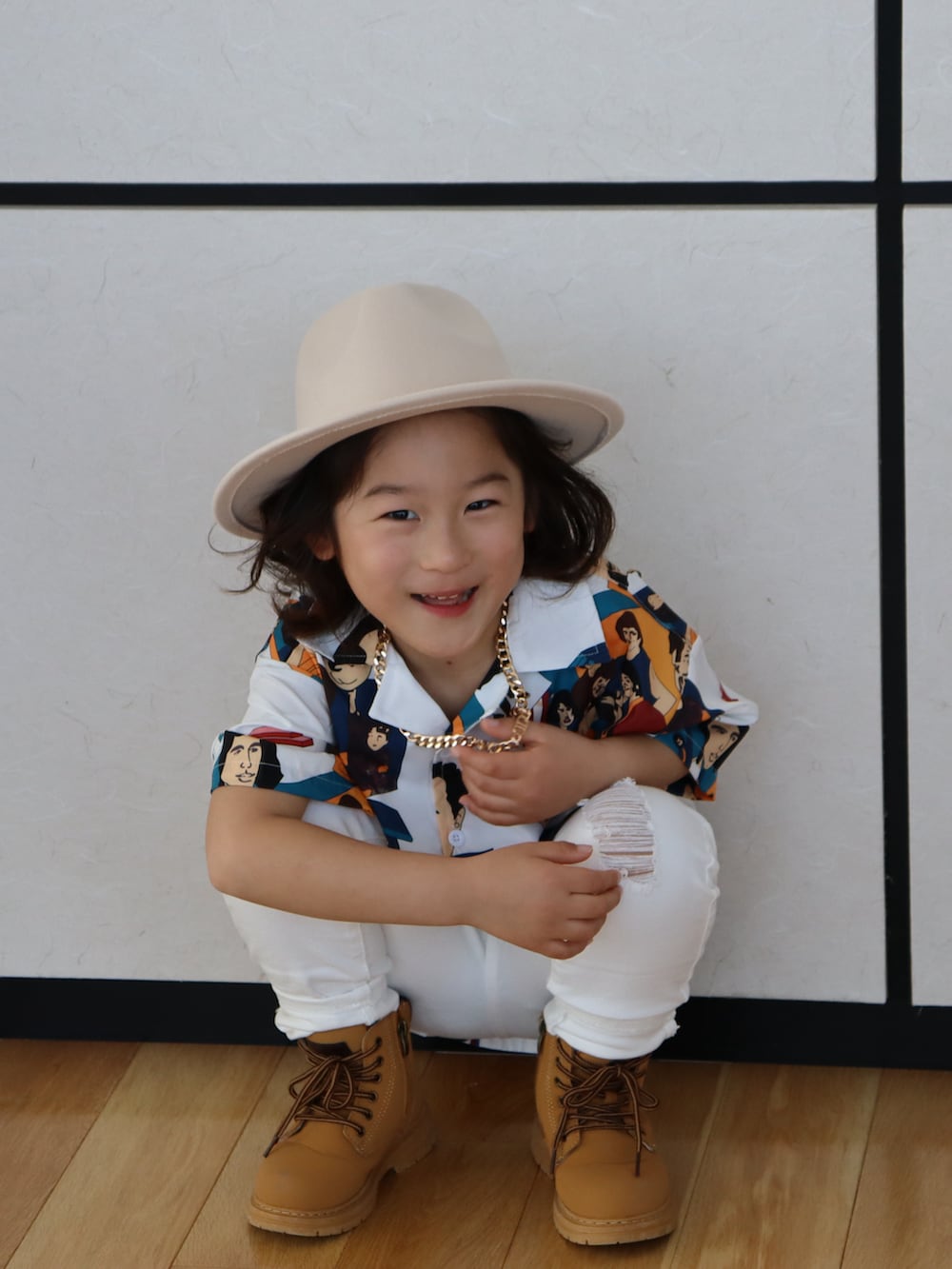 ホワイト系のデニムパンツ、ブラウン系のブーツ、ゴールド系のネックレスを着用したキッズの冬コーディネートの2枚目の写真