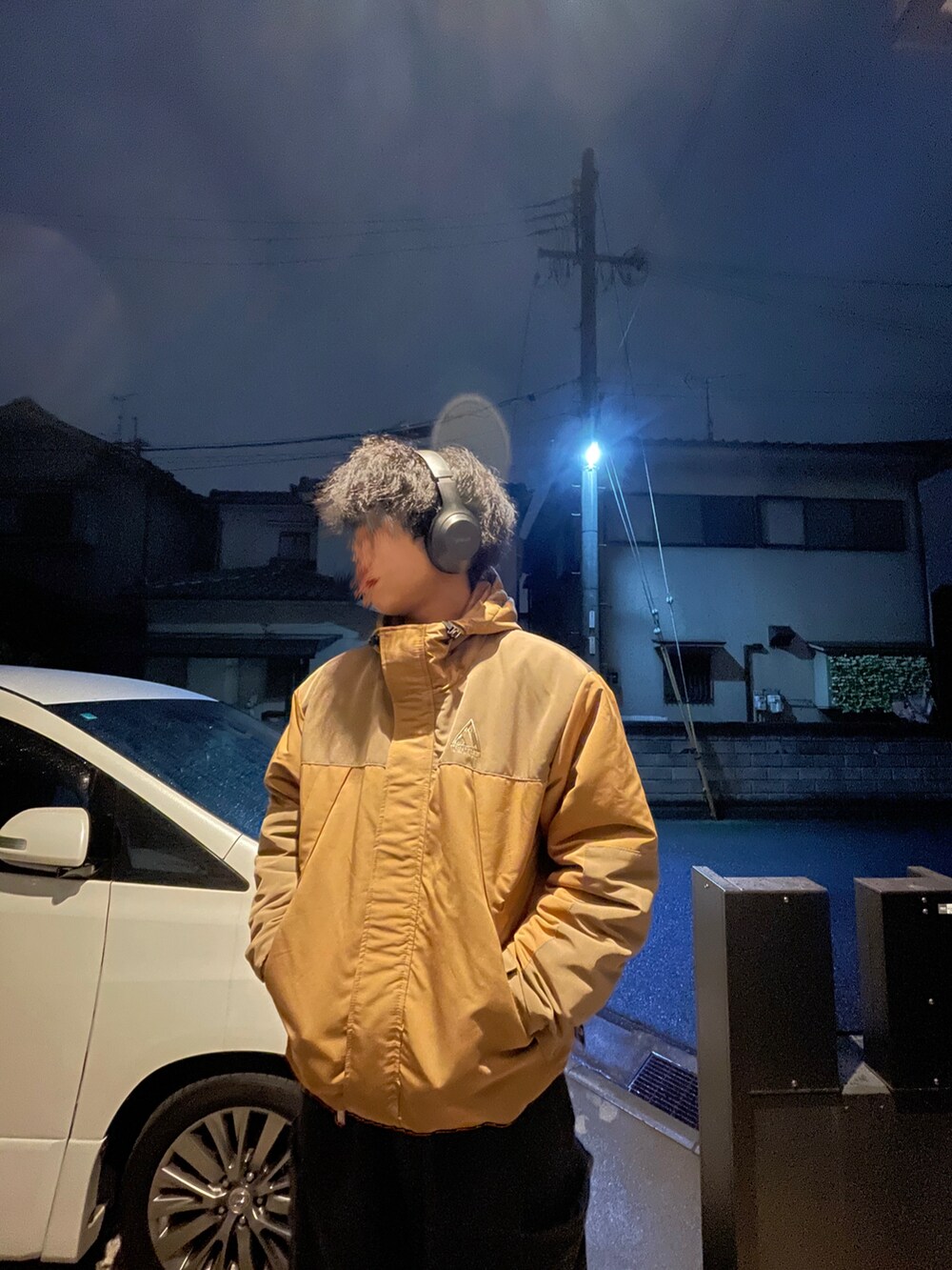 ブラウン系のマウンテンパーカー、ブラック系のカーゴパンツ、ブラウン系のコインケースを着用したメンズの冬コーディネートの2枚目の写真