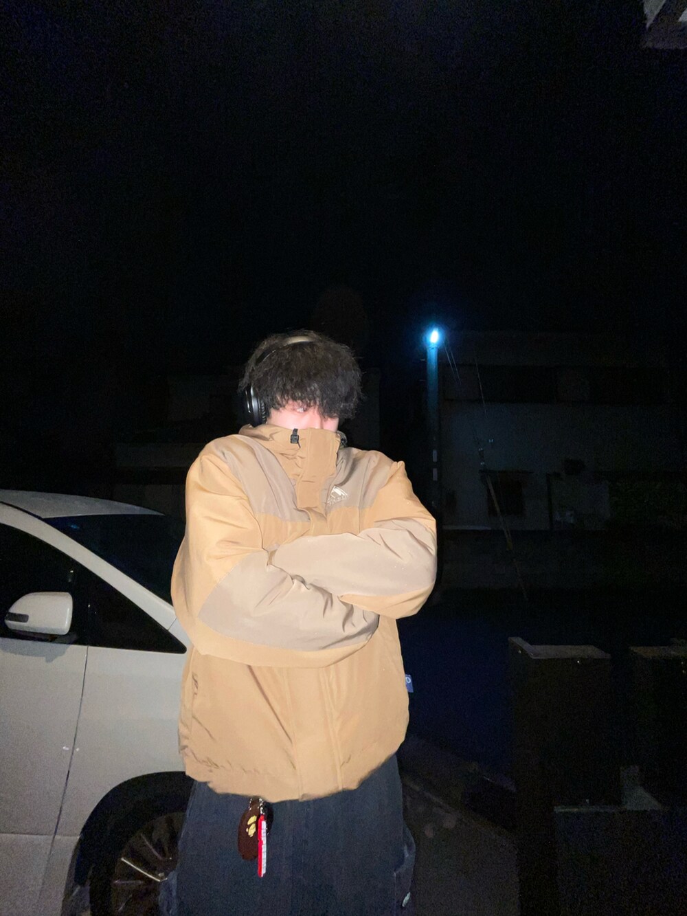 ブラウン系のマウンテンパーカー、ブラック系のカーゴパンツ、ブラウン系のコインケースを着用したメンズの冬コーディネートの3枚目の写真