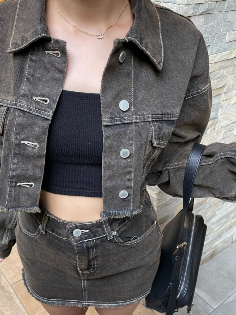 ブラック系のブーツ、ブラック系のハンドバッグ、ブラウン系のデニムジャケットを着用したレディースの秋コーディネートの5枚目の写真