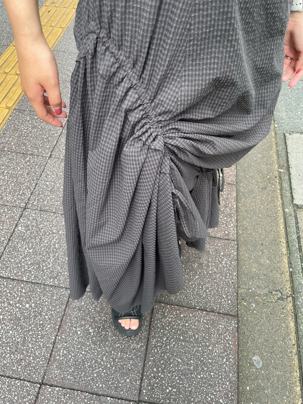 グレー系のワンピース、ブラック系のサンダル、ホワイト系のハンドバッグを着用したレディースの夏コーディネートの6枚目の写真