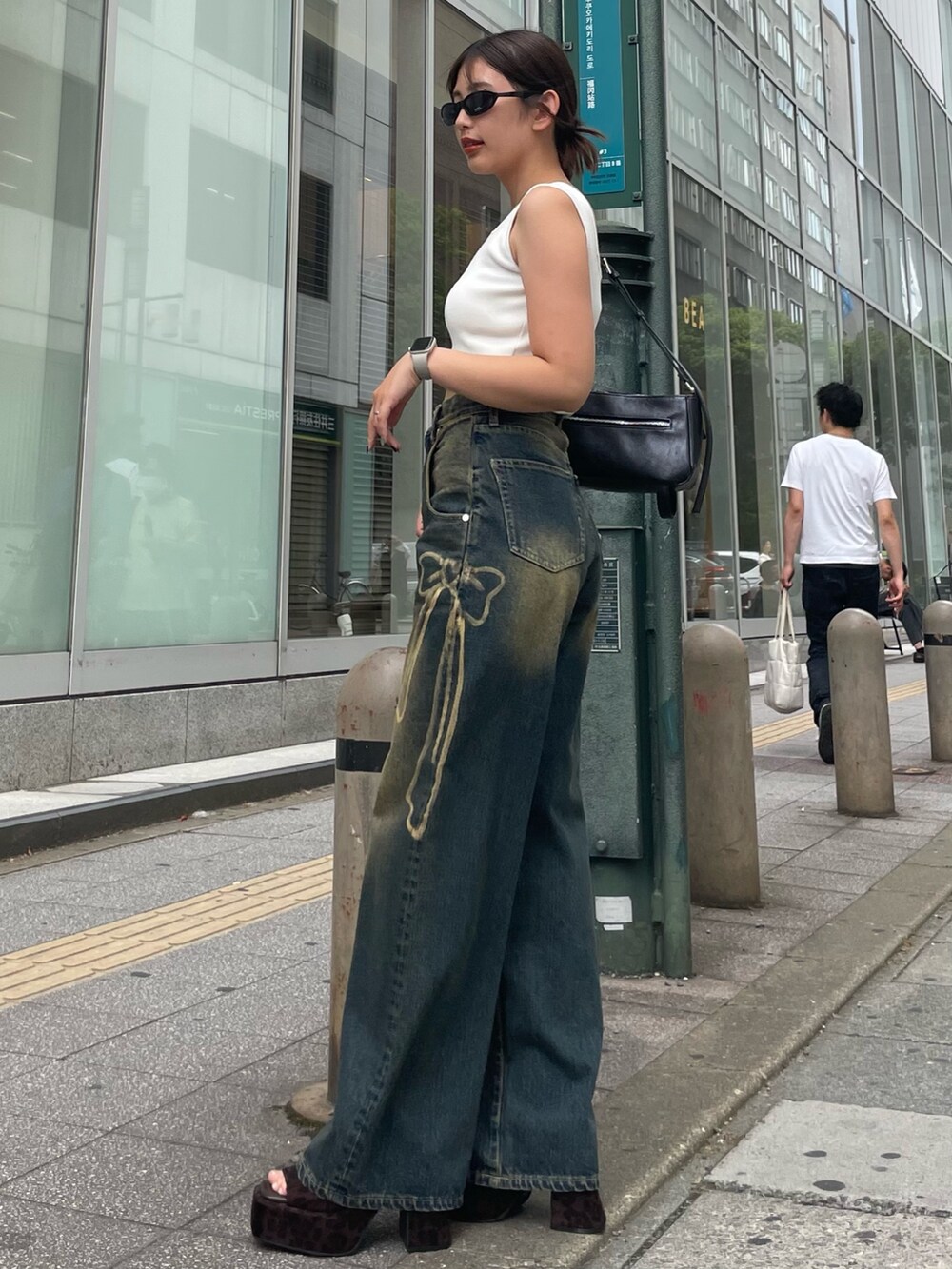 ホワイト系のTシャツ/カットソー、ブルー系のデニムパンツ、ブラウン系のサンダルを着用したレディースの夏コーディネートの2枚目の写真