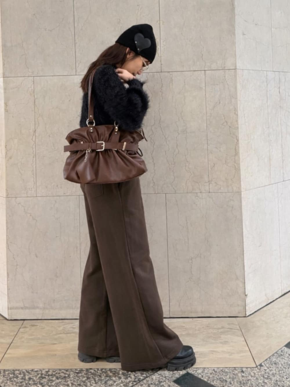 ブラック系のブーツ、ブラウン系のトートバッグ、ブラック系のニット/セーターを着用したレディースの冬コーディネートの2枚目の写真