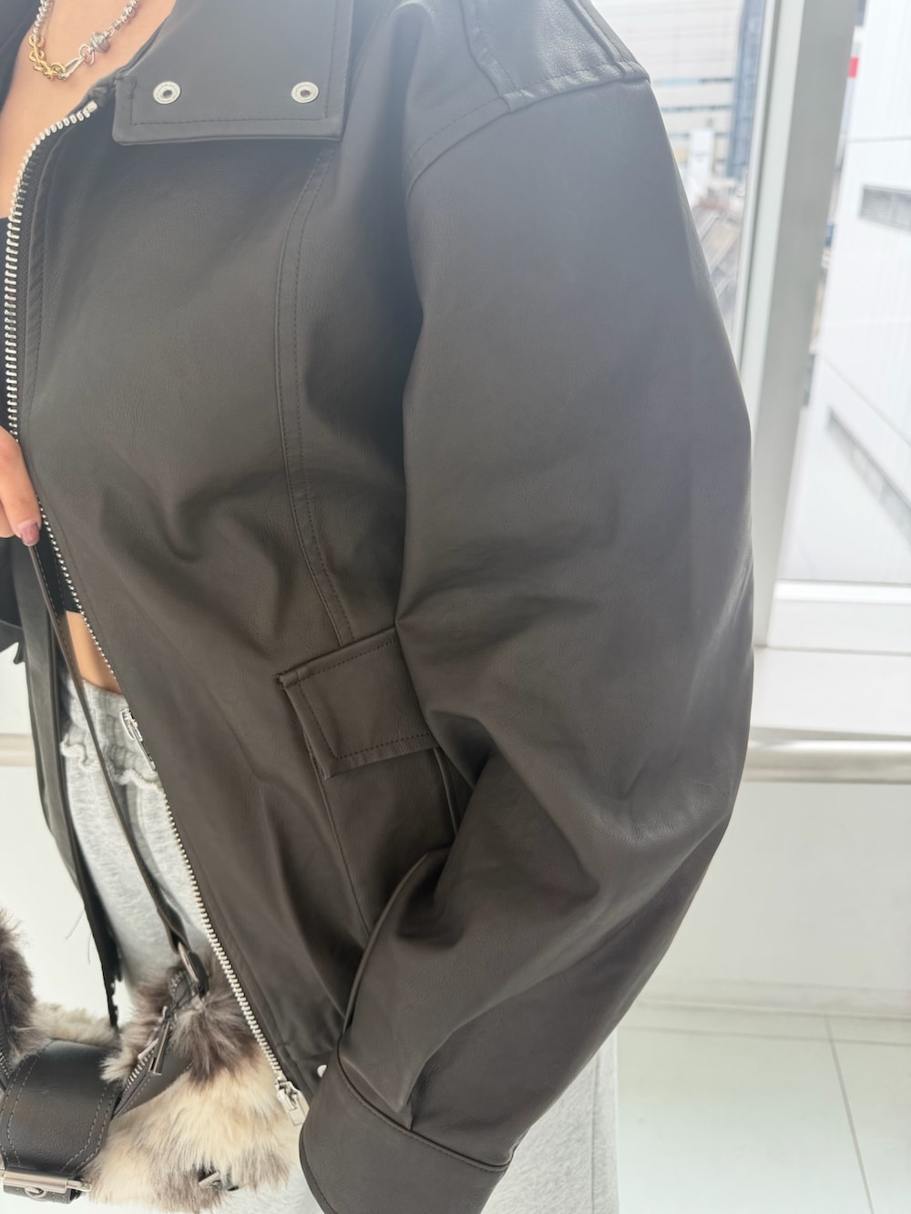 ブラウン系のブルゾン、ブラック系のTシャツ/カットソー、ブラウン系のショルダーバッグを着用したレディースの秋コーディネートの5枚目の写真