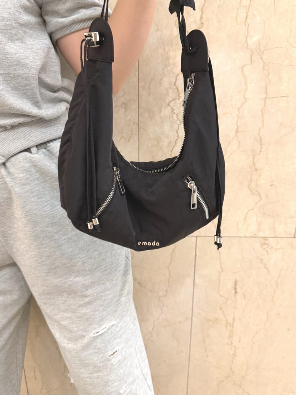グレー系のスウェット、グレー系のスウェットパンツ、ブラック系のショルダーバッグを着用したレディースの夏コーディネートの6枚目の写真