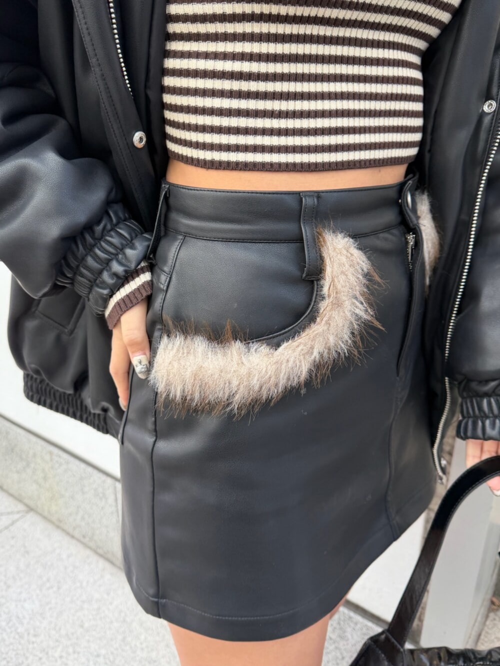 ブラック系のブルゾン、ブラック系のスカート、ブラウン系のニット/セーターを着用したレディースの冬コーディネートの8枚目の写真