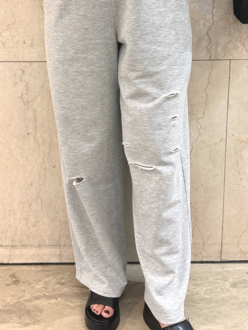 グレー系のスウェット、グレー系のスウェットパンツ、ブラック系のショルダーバッグを着用したレディースの夏コーディネートの7枚目の写真