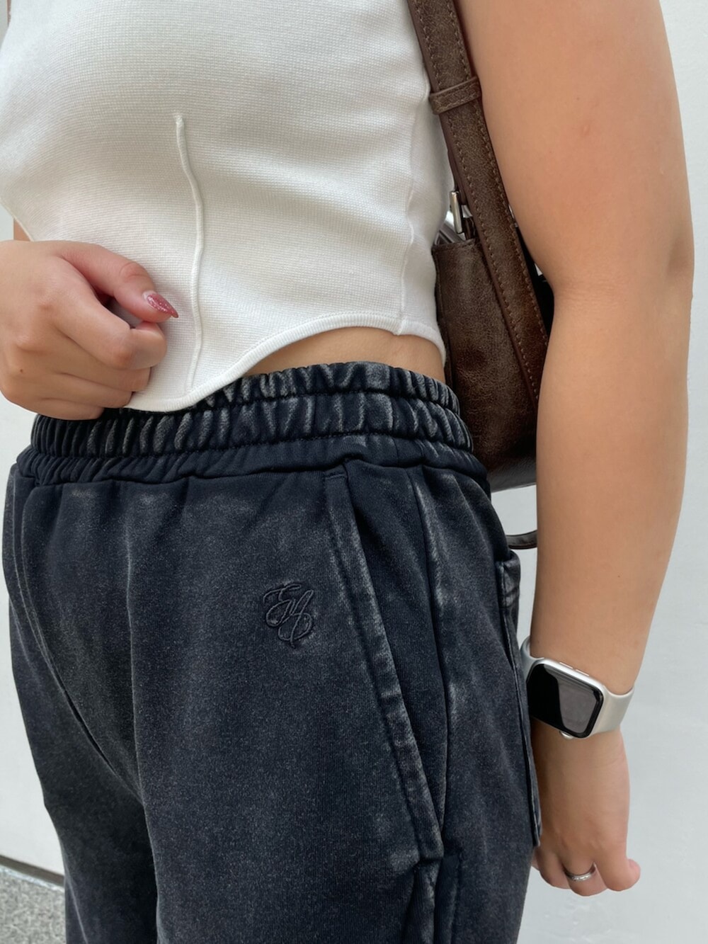 ブラック系のサンダル、ブラウン系のハンドバッグ、ホワイト系のニット/セーターを着用したレディースの夏コーディネートの5枚目の写真