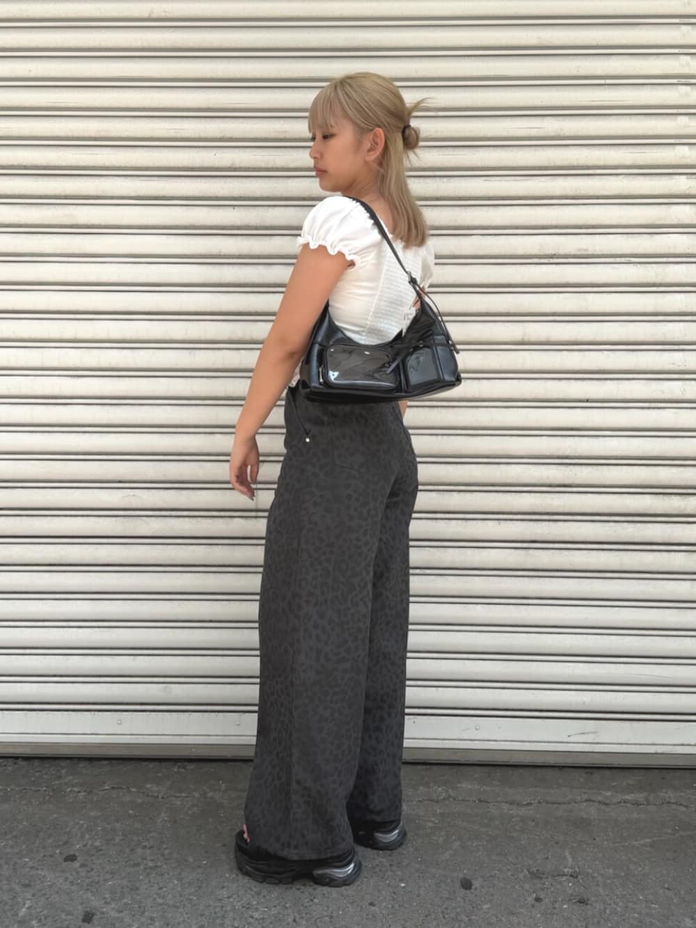 ブラック系のサンダル、グレー系のその他パンツ、ブラック系のハンドバッグを着用したレディースの夏コーディネートの2枚目の写真