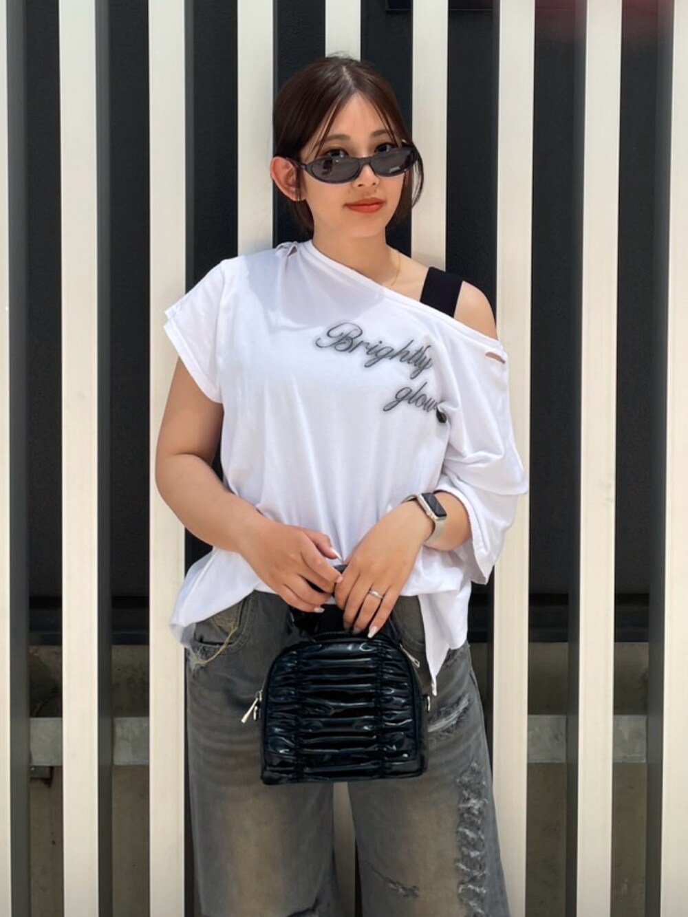 ホワイト系のTシャツ/カットソー、ブラック系のタンクトップ、ブラック系のハンドバッグを着用したレディースの春コーディネートの4枚目の写真