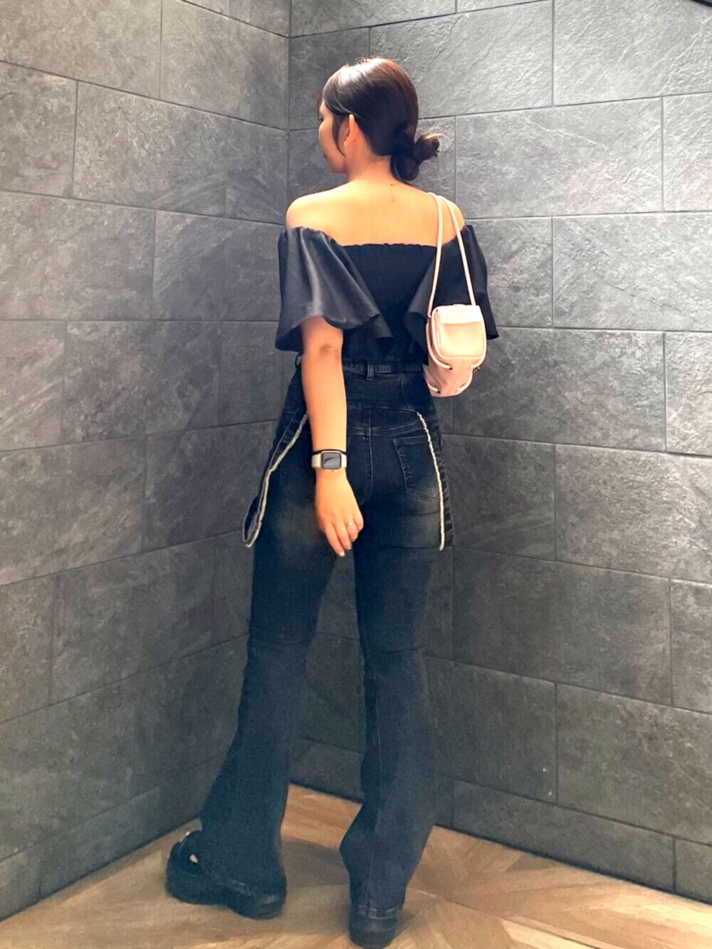 ブラック系のサンダル、ピンク系のハンドバッグ、ブルー系のデニムパンツを着用したレディースの夏コーディネートの3枚目の写真