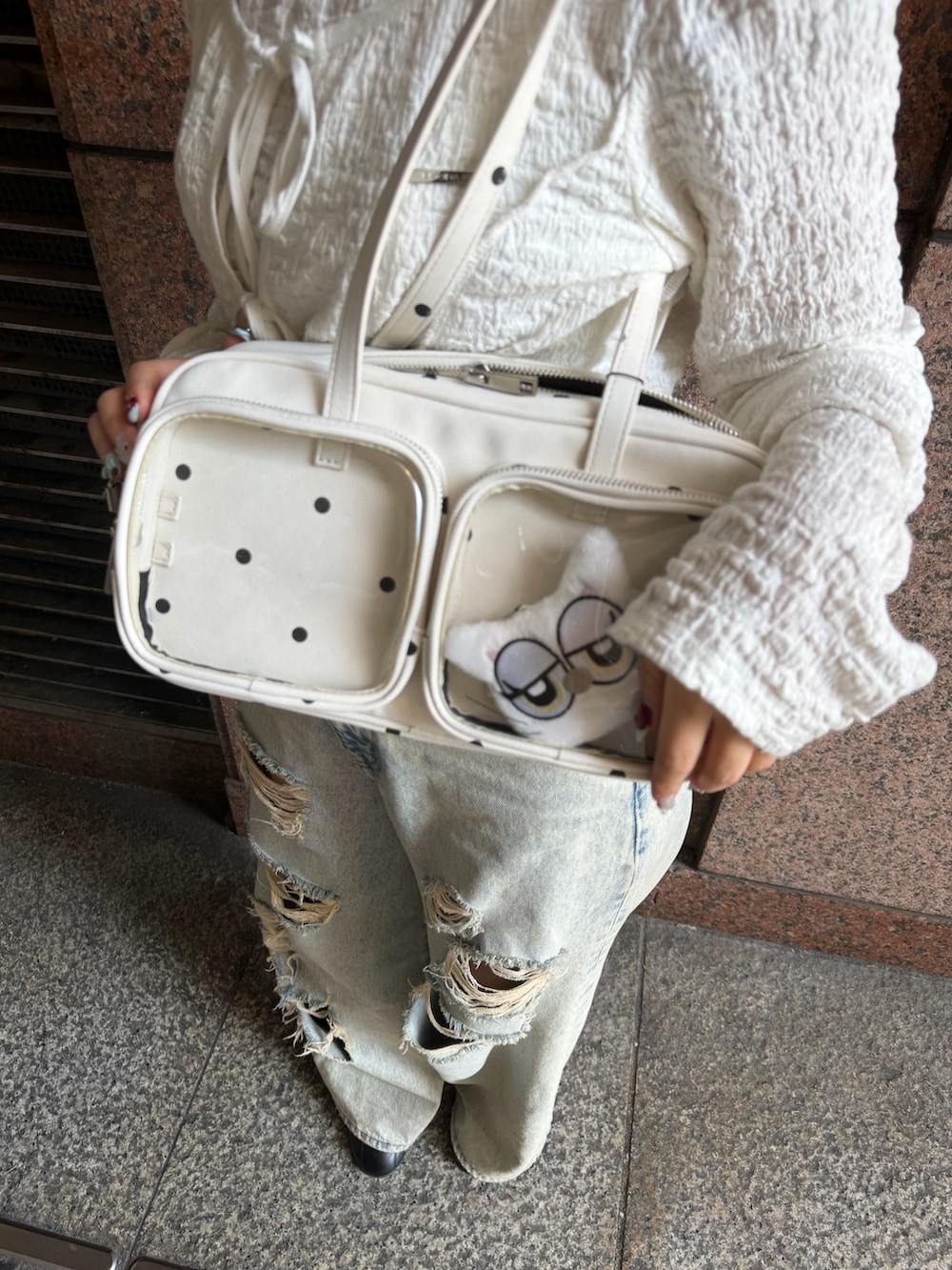 ホワイト系のTシャツ/カットソー、ブルー系のデニムパンツ、ホワイト系のショルダーバッグを着用したレディースの春コーディネートの5枚目の写真