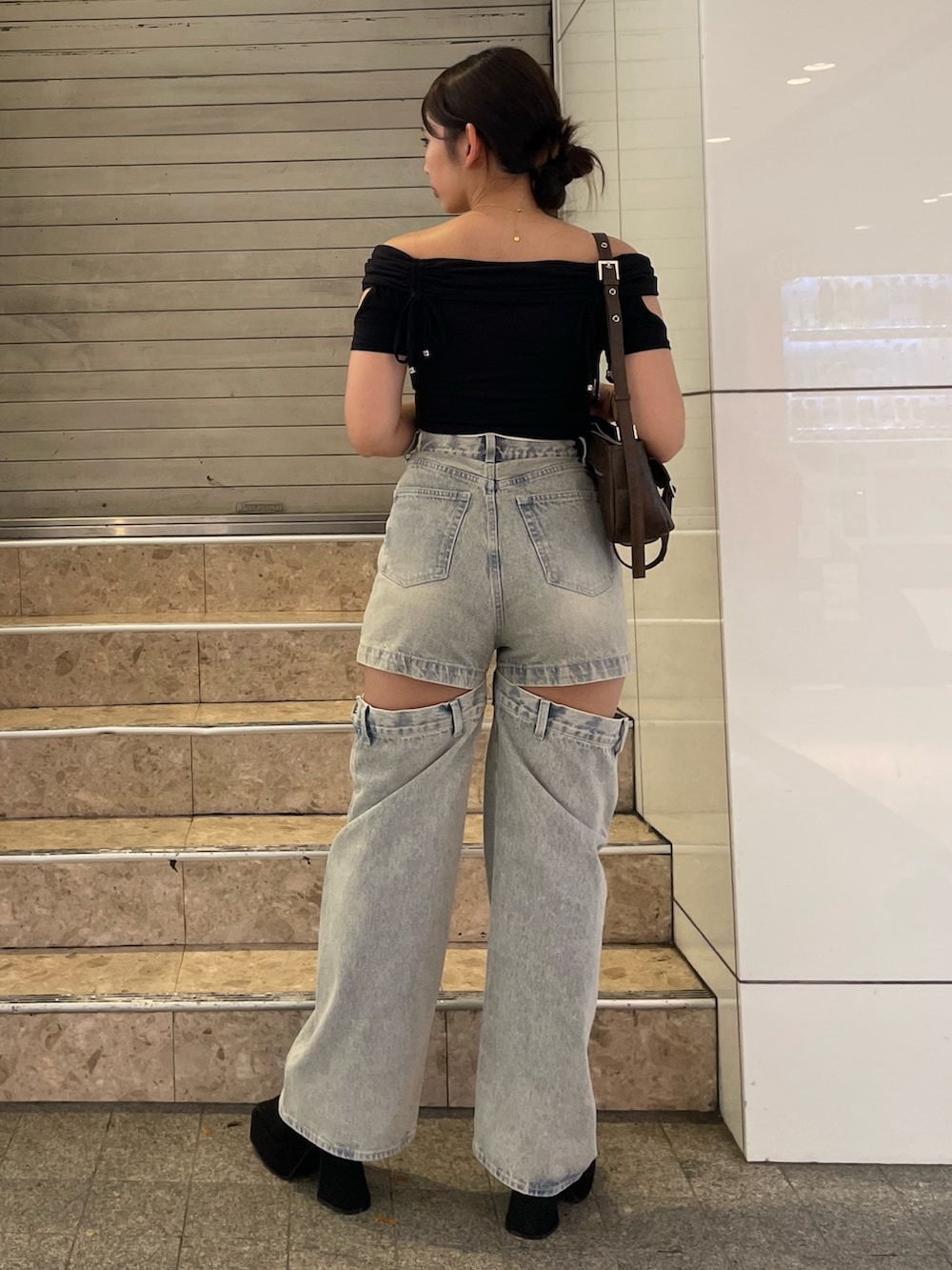 ブラック系のTシャツ/カットソー、ブルー系のデニムパンツ、ブラック系のサンダルを着用したレディースの夏コーディネートの3枚目の写真