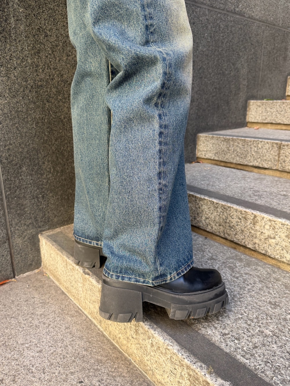 ブラック系のニット/セーター、ブルー系のデニムパンツ、ブラック系のショルダーバッグを着用したレディースの冬コーディネートの9枚目の写真