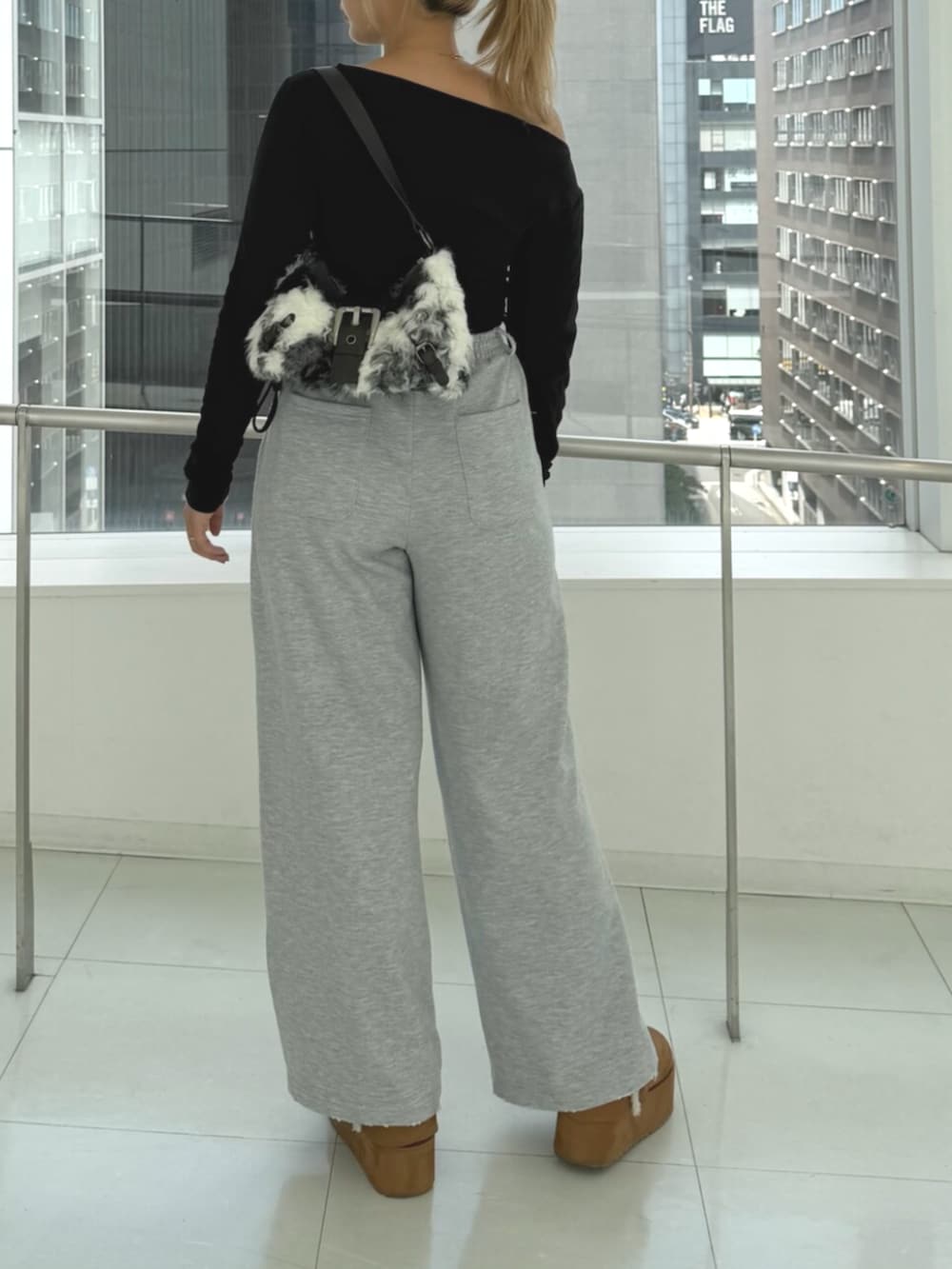 グレー系のスウェットパンツ、ブラウン系のスリッポン、ブラック系のTシャツ/カットソーを着用したレディースの秋コーディネートの3枚目の写真