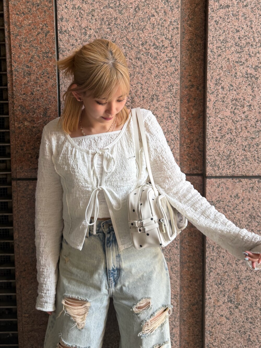 ホワイト系のTシャツ/カットソー、ブルー系のデニムパンツ、ホワイト系のショルダーバッグを着用したレディースの春コーディネートの4枚目の写真
