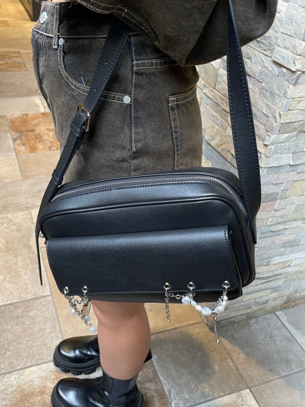 ブラック系のブーツ、ブラック系のハンドバッグ、ブラウン系のデニムジャケットを着用したレディースの秋コーディネートの6枚目の写真