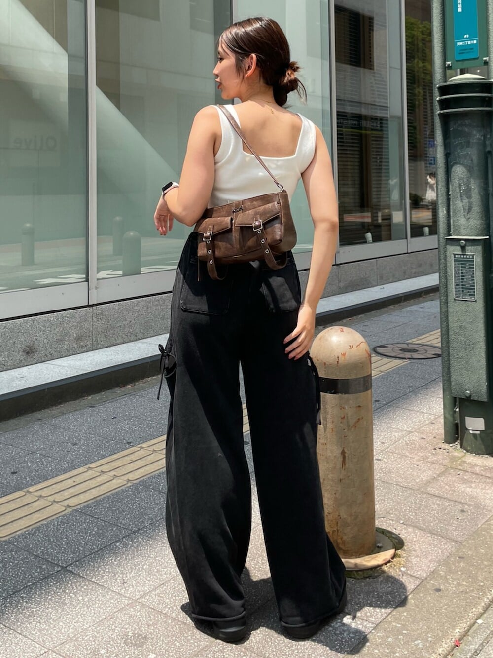 ブラック系のサンダル、ブラウン系のハンドバッグ、ホワイト系のニット/セーターを着用したレディースの夏コーディネートの3枚目の写真