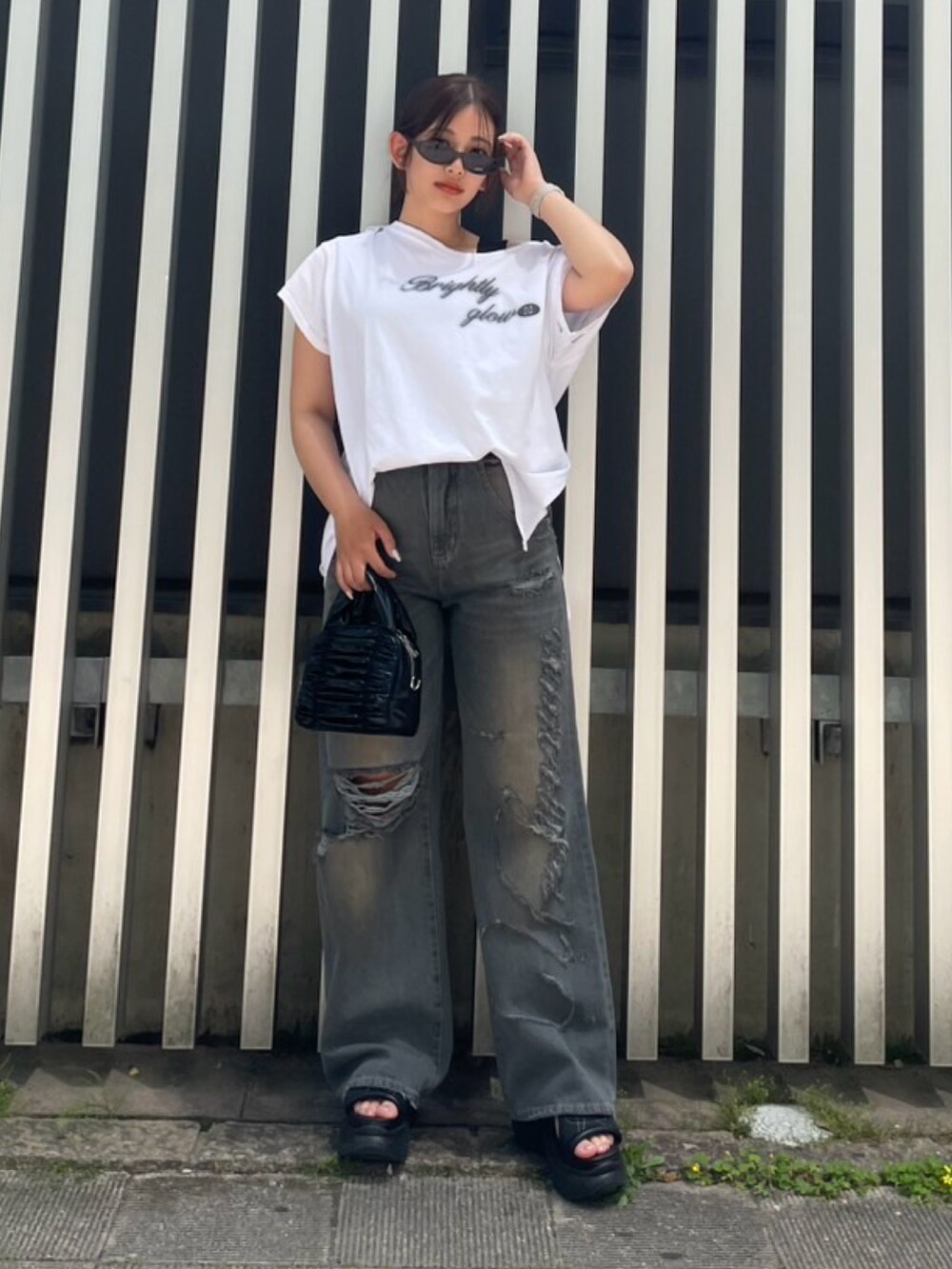 ホワイト系のTシャツ/カットソー、ブラック系のタンクトップ、ブラック系のハンドバッグを着用したレディースの春コーディネートの3枚目の写真