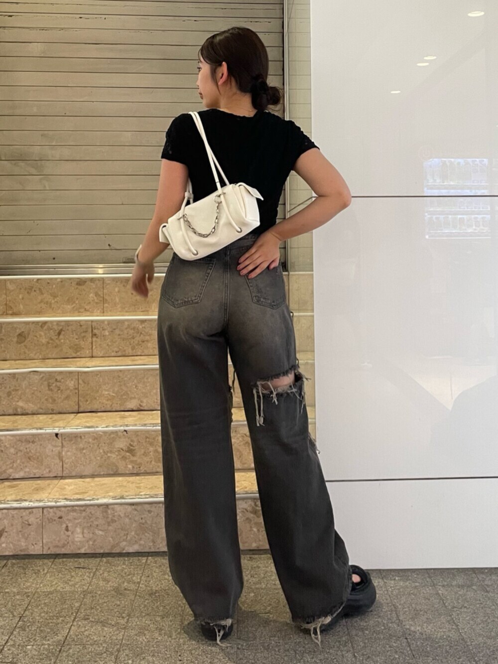 ブラック系のサンダル、ホワイト系のハンドバッグ、ブラック系のTシャツ/カットソーを着用したレディースの夏コーディネートの4枚目の写真