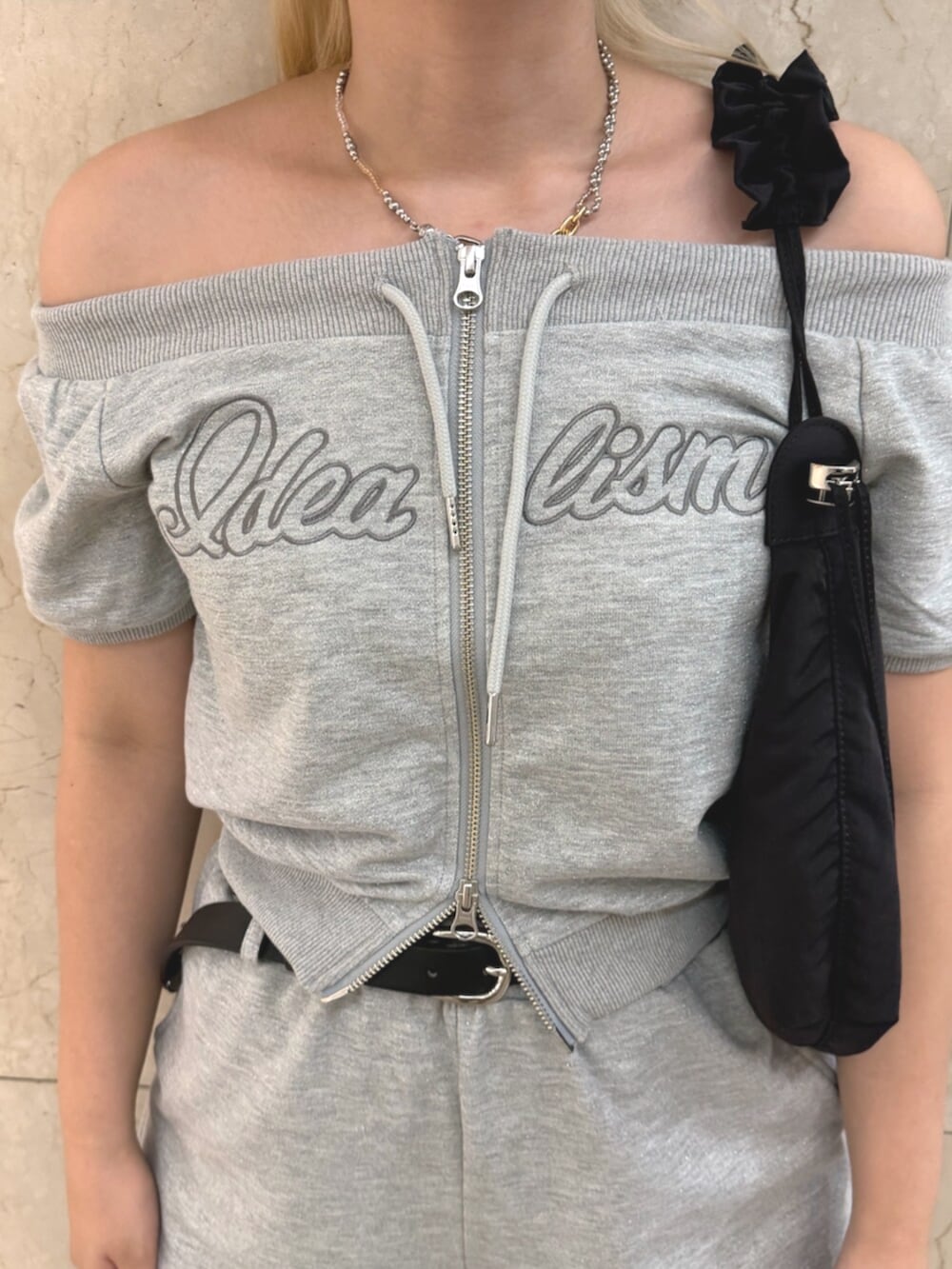 グレー系のスウェット、グレー系のスウェットパンツ、ブラック系のショルダーバッグを着用したレディースの夏コーディネートの5枚目の写真