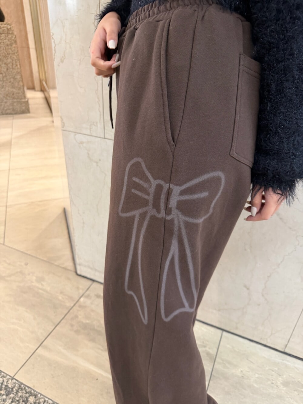 ブラック系のブーツ、ブラウン系のトートバッグ、ブラック系のニット/セーターを着用したレディースの冬コーディネートの7枚目の写真