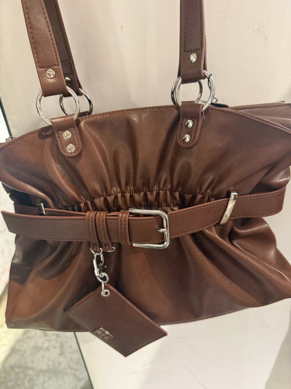 ブラック系のブーツ、ブラウン系のトートバッグ、ブラック系のニット/セーターを着用したレディースの冬コーディネートの9枚目の写真