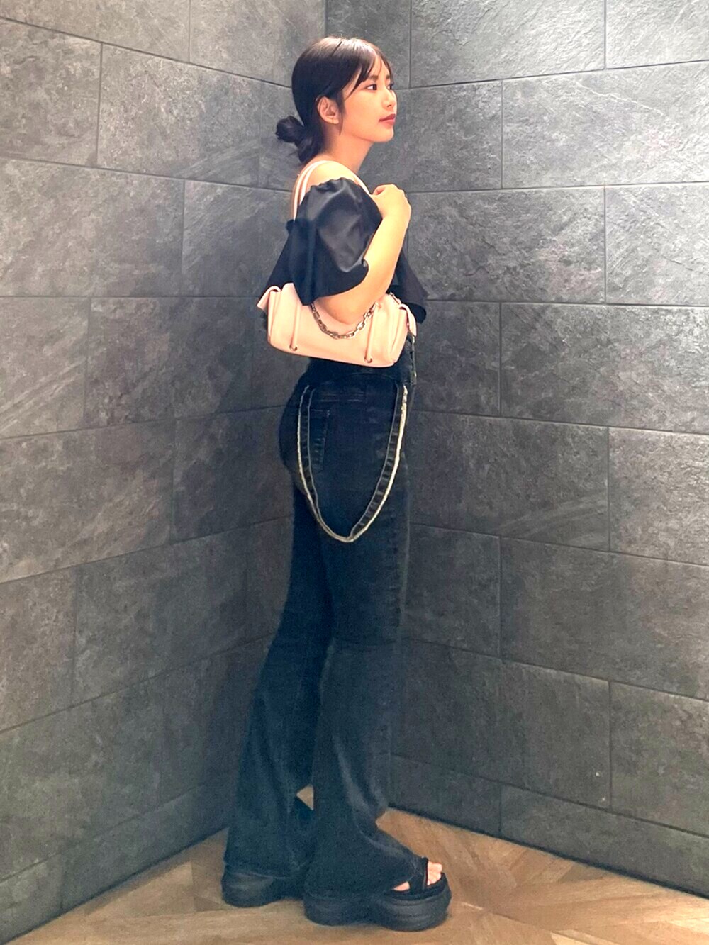 ブラック系のサンダル、ピンク系のハンドバッグ、ブルー系のデニムパンツを着用したレディースの夏コーディネートの2枚目の写真