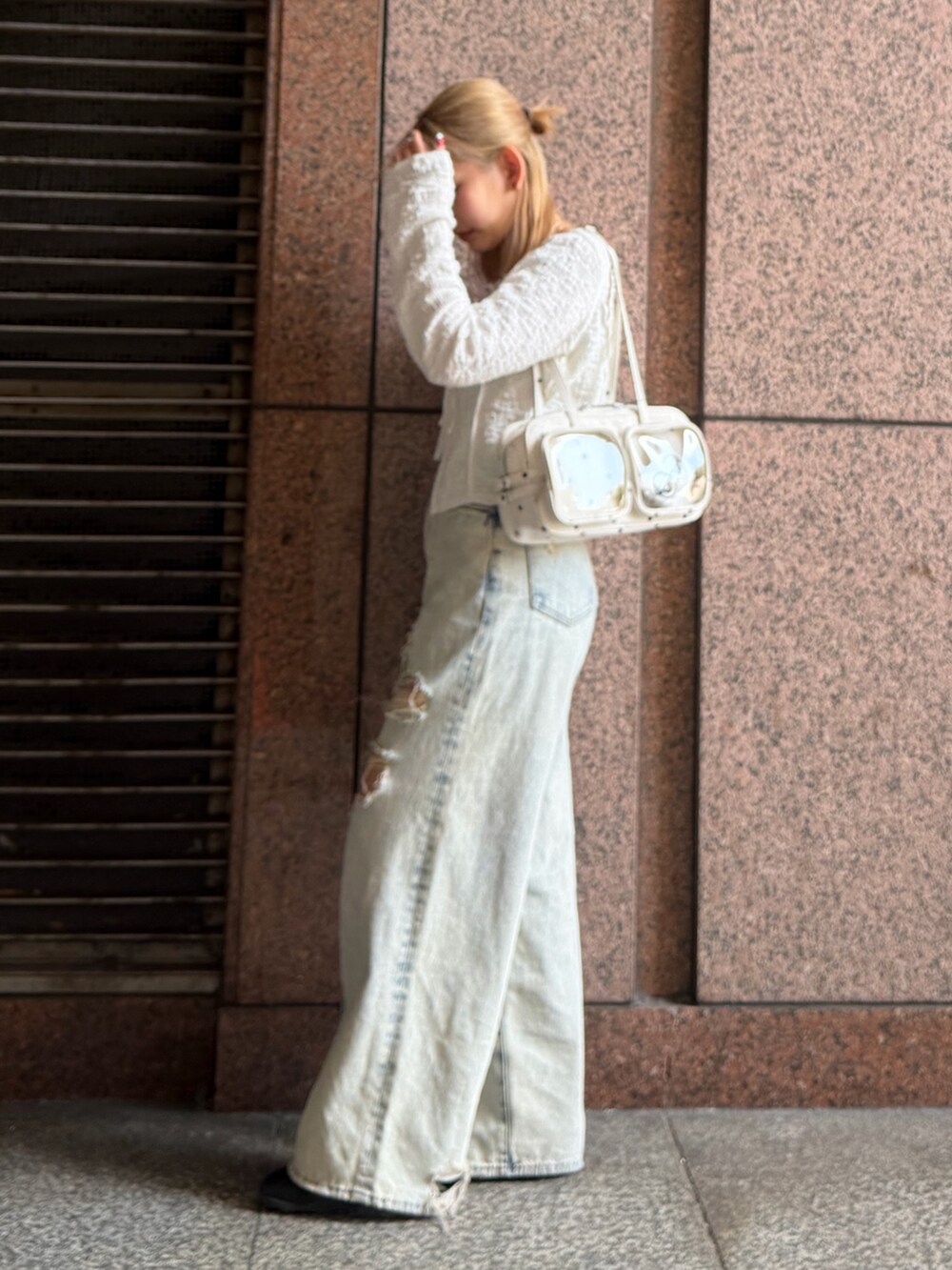 ホワイト系のTシャツ/カットソー、ブルー系のデニムパンツ、ホワイト系のショルダーバッグを着用したレディースの春コーディネートの2枚目の写真