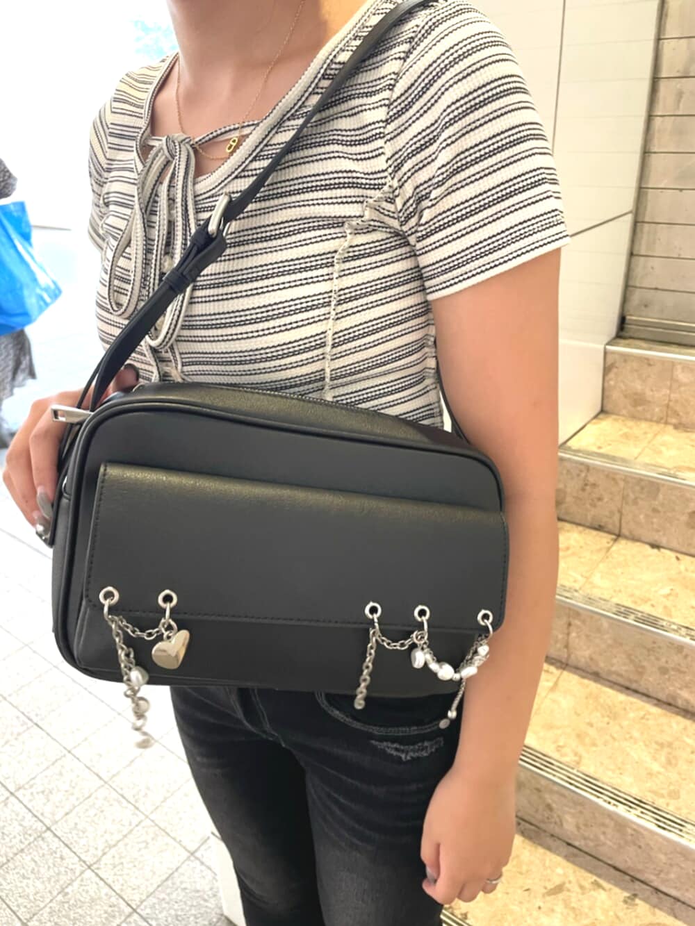 その他のTシャツ/カットソー、ブラック系のデニムパンツ、ブラック系のサンダルを着用したレディースの秋コーディネートの6枚目の写真