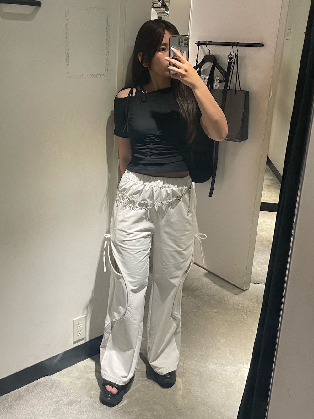 ブラック系のTシャツ/カットソー、ホワイト系のその他パンツ、ブラック系のサンダルを着用したレディースの春コーディネートの2枚目の写真