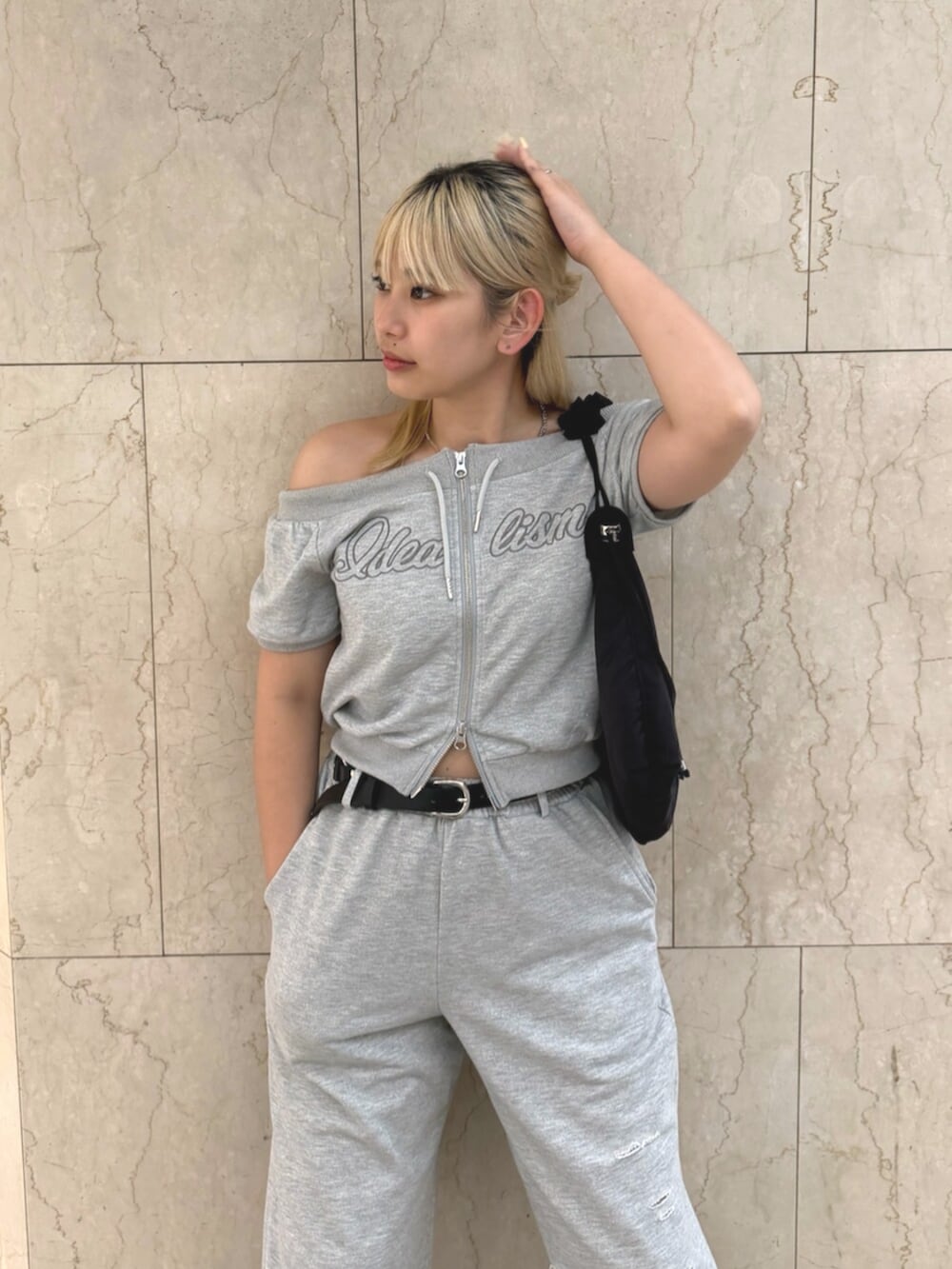 グレー系のスウェット、グレー系のスウェットパンツ、ブラック系のショルダーバッグを着用したレディースの夏コーディネートの4枚目の写真
