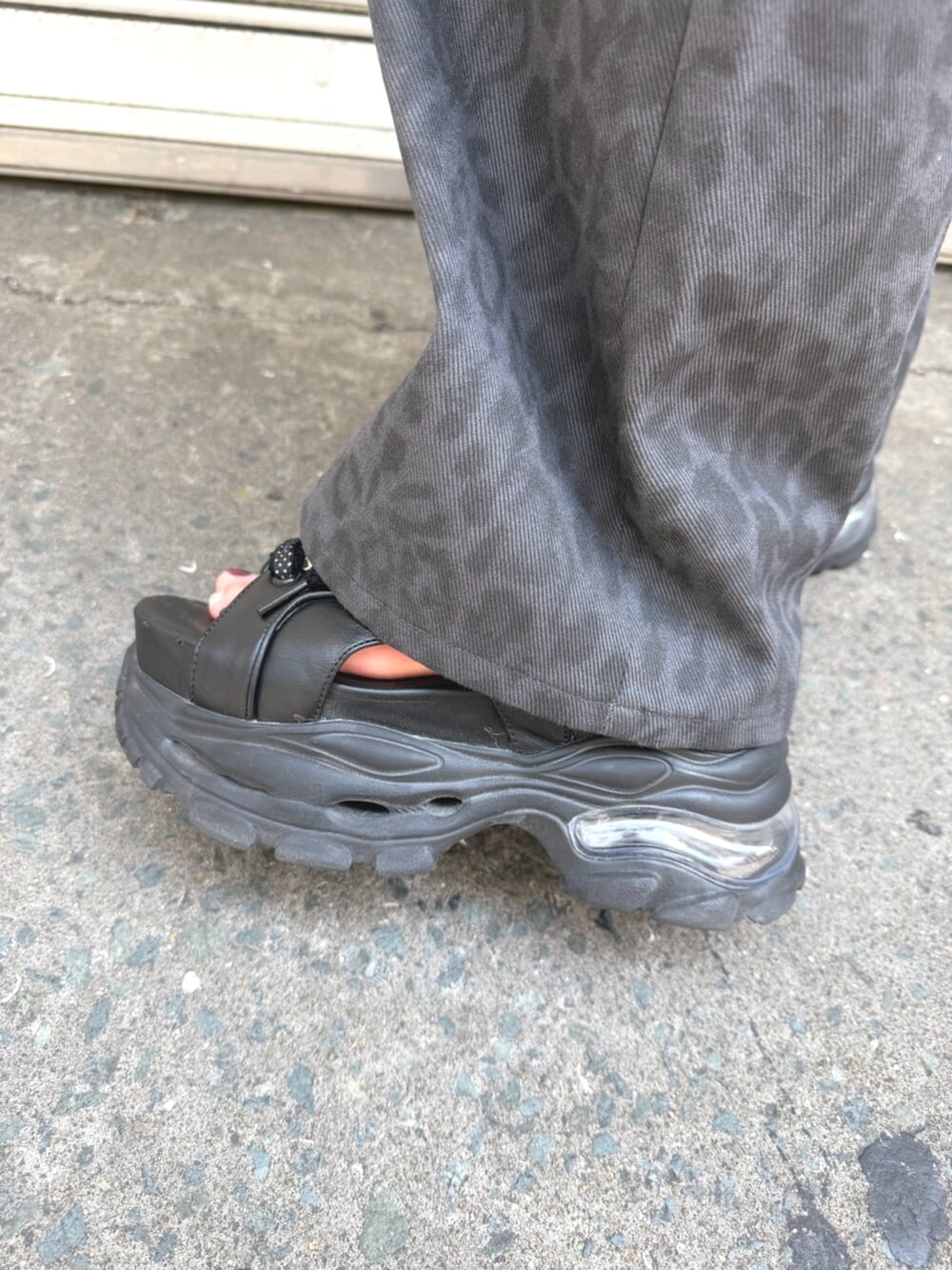 ブラック系のサンダル、グレー系のその他パンツ、ブラック系のハンドバッグを着用したレディースの夏コーディネートの8枚目の写真