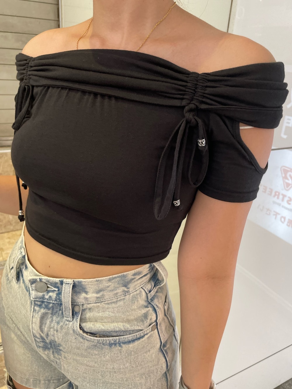 ブラック系のTシャツ/カットソー、ブルー系のデニムパンツ、ブラック系のサンダルを着用したレディースの夏コーディネートの6枚目の写真