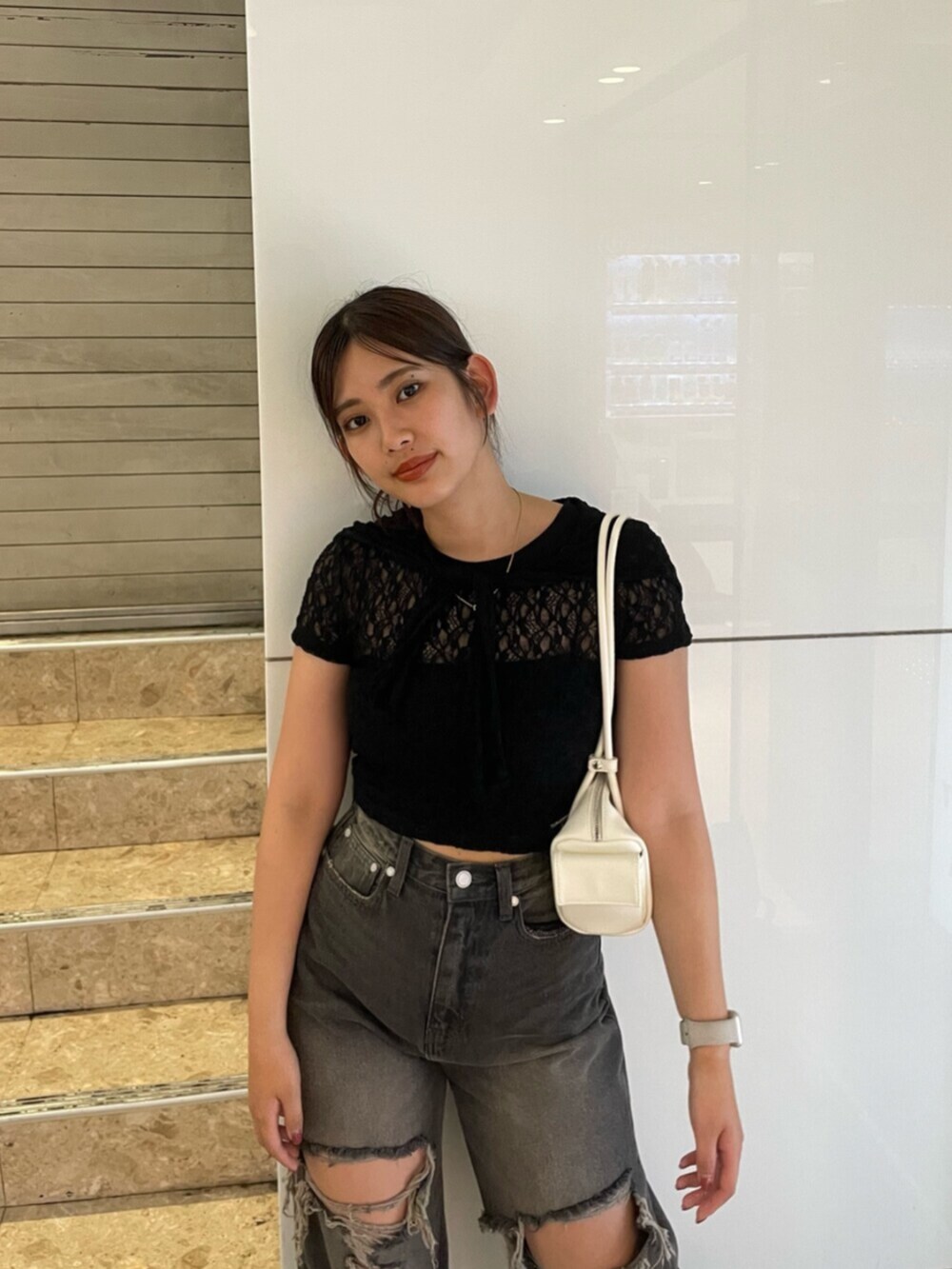 ブラック系のサンダル、ホワイト系のハンドバッグ、ブラック系のTシャツ/カットソーを着用したレディースの夏コーディネートの6枚目の写真