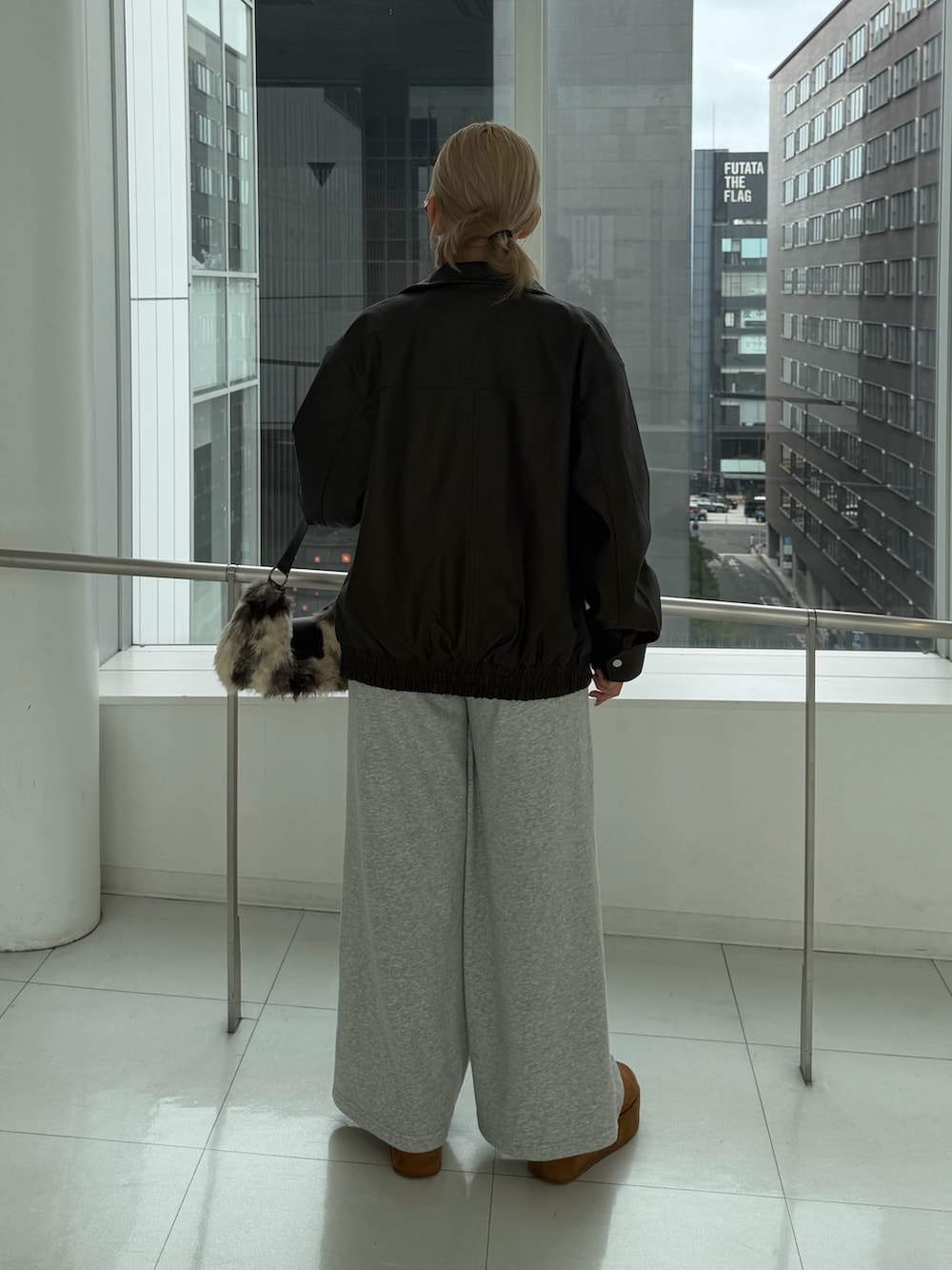ブラウン系のブルゾン、ブラック系のTシャツ/カットソー、ブラウン系のショルダーバッグを着用したレディースの秋コーディネートの3枚目の写真