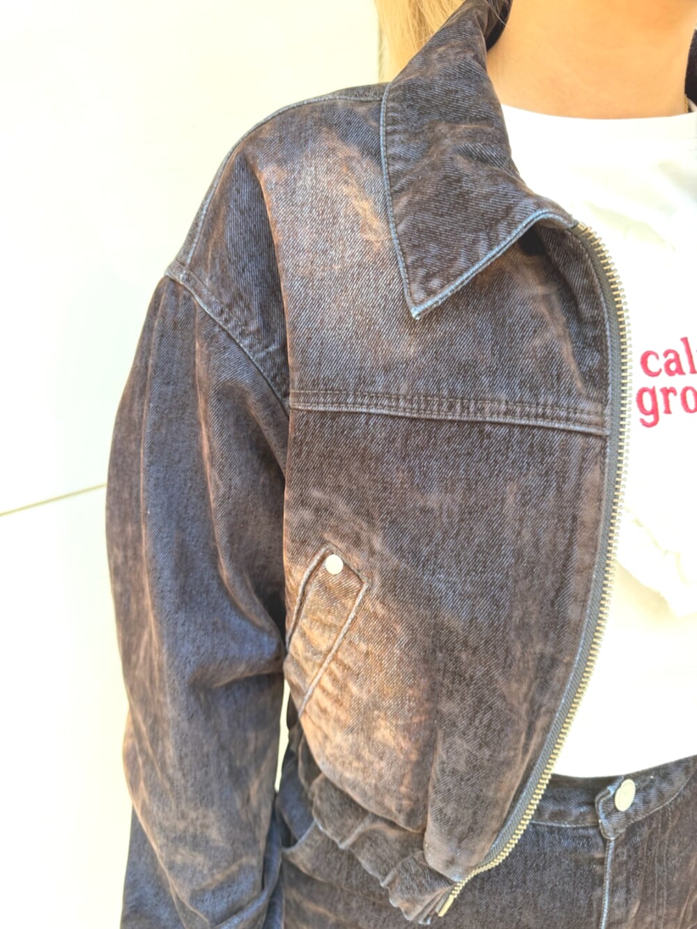 ブラウン系のブルゾン、ホワイト系のTシャツ/カットソー、ブラウン系のデニムパンツを着用したレディースの夏コーディネートの4枚目の写真