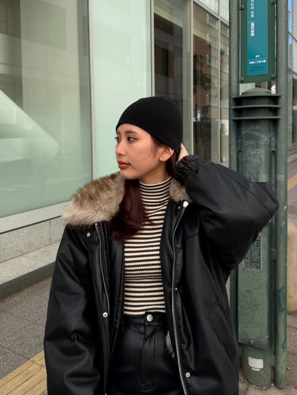 ブラック系のブルゾン、ブラック系のスカート、ブラウン系のニット/セーターを着用したレディースの冬コーディネートの4枚目の写真