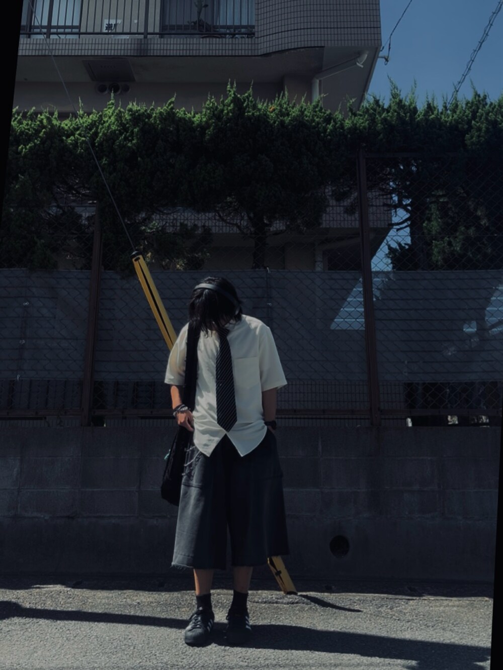 ホワイト系のスニーカー、ブラック系のスウェットパンツ、ホワイト系のシャツ/ブラウスを着用したメンズの夏コーディネートの2枚目の写真