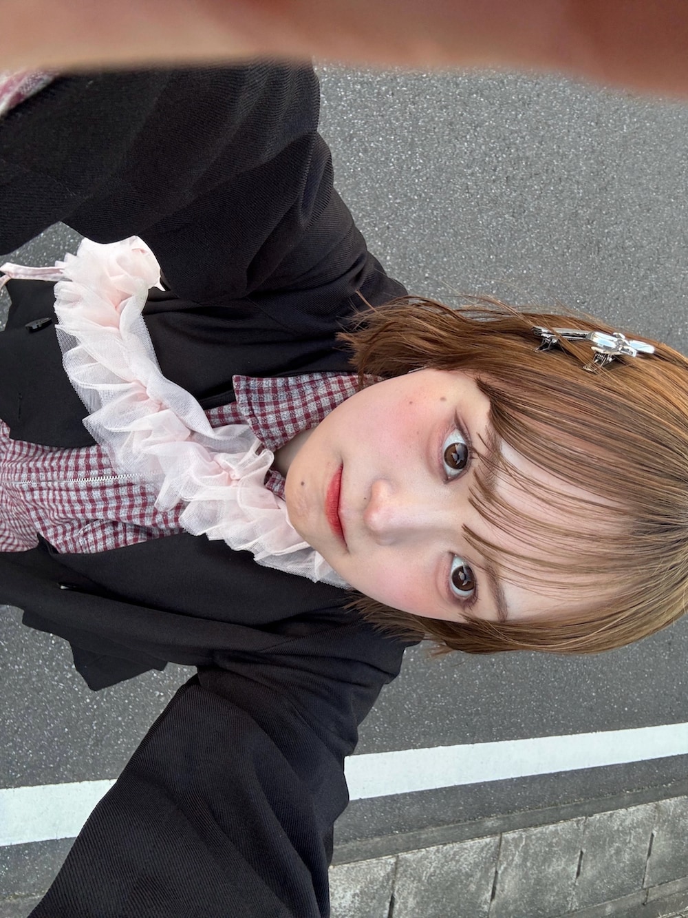 ブラック系のノーカラージャケット、ホワイト系のスカート、ブルー系のデニムパンツを着用したレディースの冬コーディネートの3枚目の写真