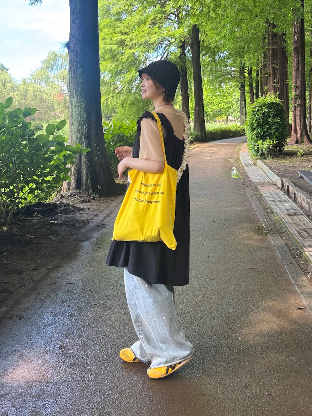 ブラック系のワンピース、ベージュ系のTシャツ/カットソー、ブルー系のデニムパンツを着用したレディースの夏コーディネートの2枚目の写真