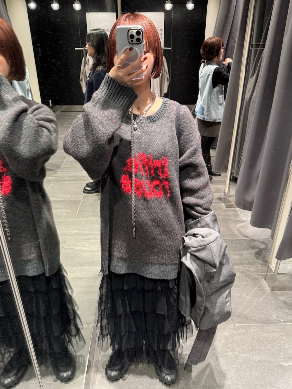 グレー系のテーラードジャケット、グレー系のニット/セーター、ブラック系のスニーカーを着用したレディースの冬コーディネートの3枚目の写真