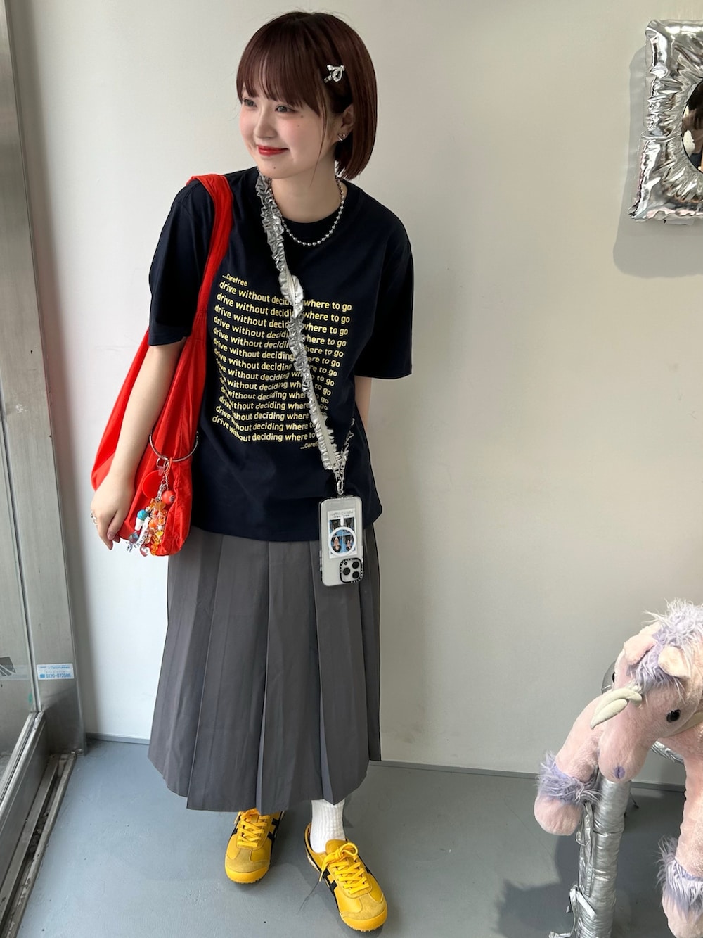 ブルー系のTシャツ/カットソー、グレー系のスカート、イエロー系のスニーカーを着用したレディースの夏コーディネートの2枚目の写真