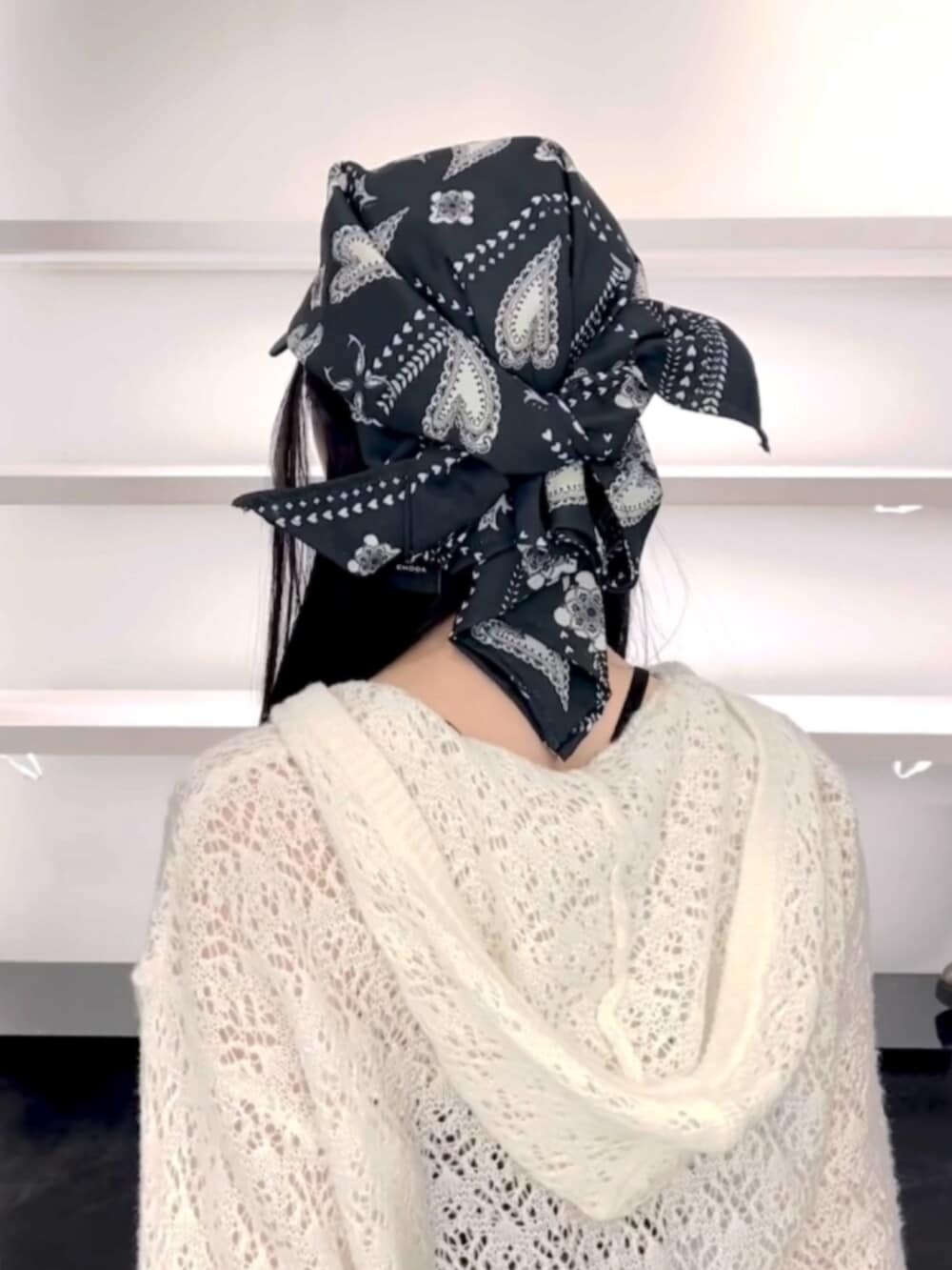 ブラック系のサンダル、ホワイト系のパーカー、ブラック系のスカートを着用したレディースの春コーディネートの7枚目の写真