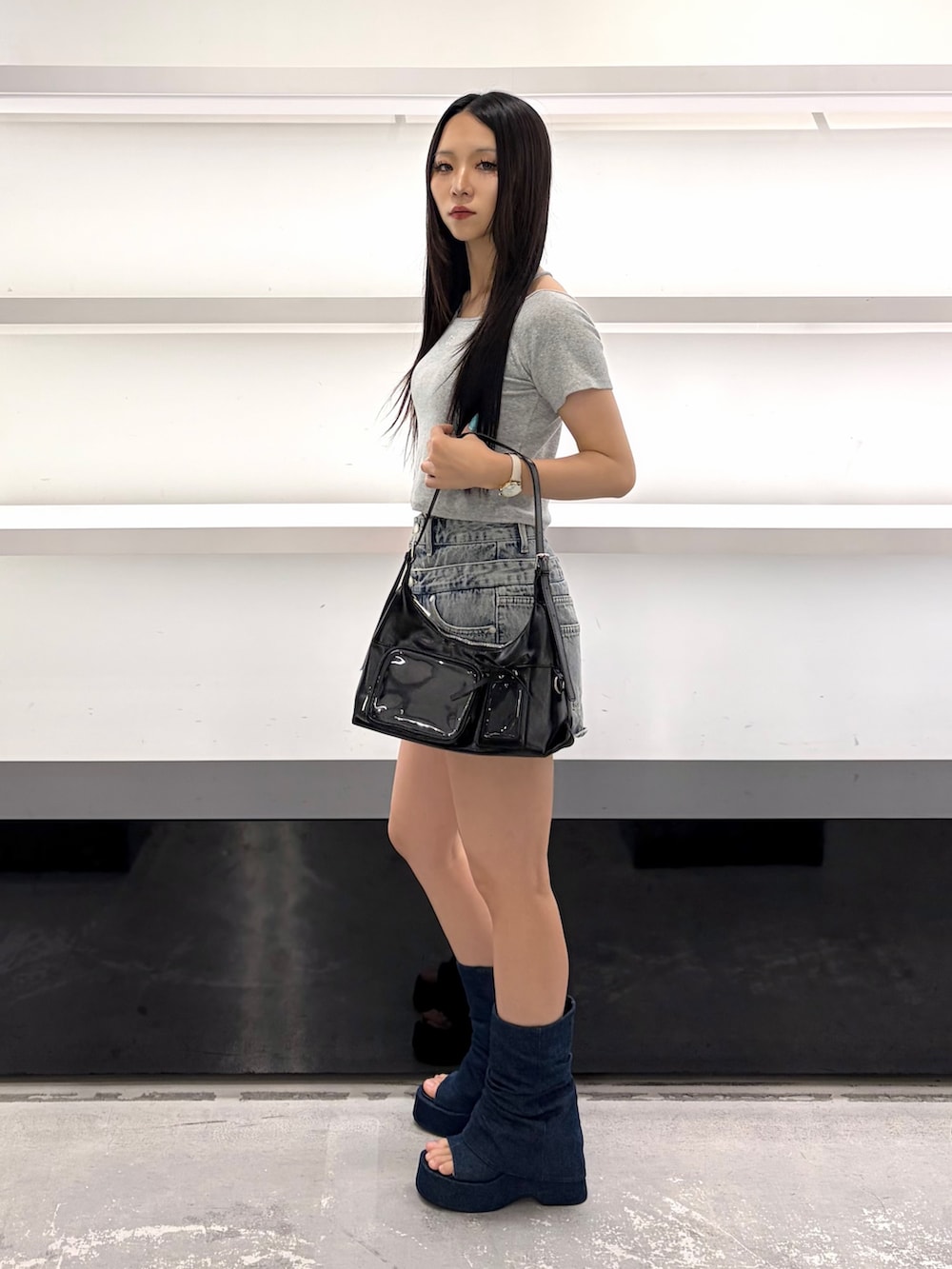ブルー系のスカート、ブラック系のハンドバッグ、ブルー系のサンダルを着用したレディースの夏コーディネートの3枚目の写真