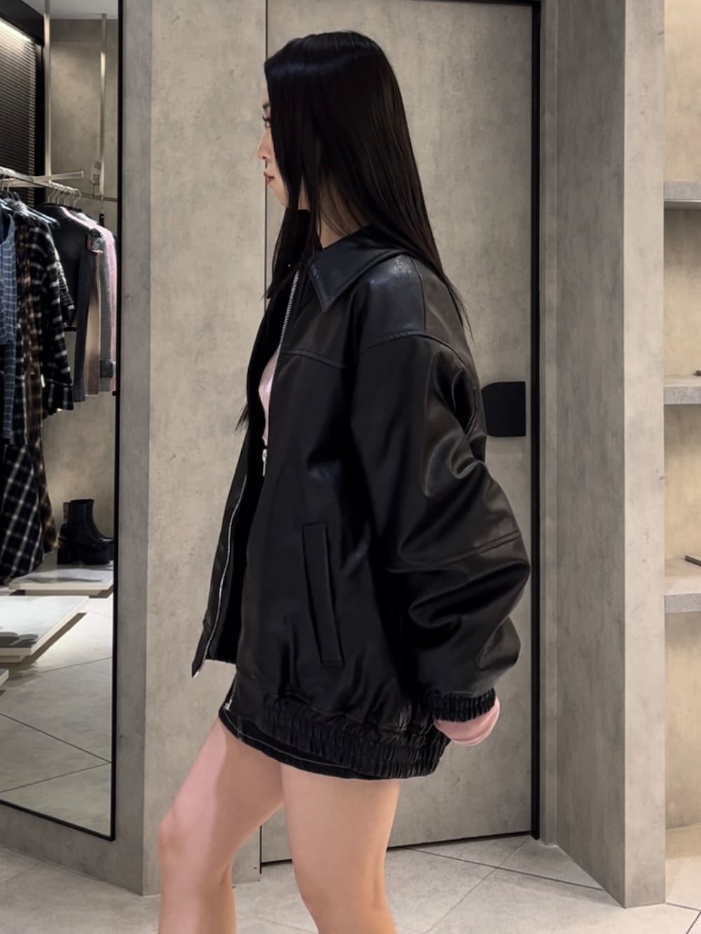 ブラック系のブルゾン、ピンク系のTシャツ/カットソー、ブルー系のスカートを着用したレディースの冬コーディネートの6枚目の写真